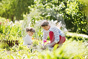 Grandmother with her granddaughter working in the garden.