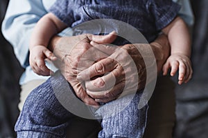 Grandmother holding her grandchild. Old and young hands. Age concept. Family care concept