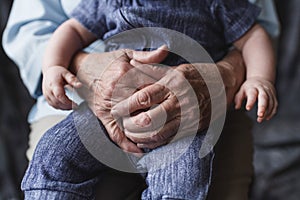 Grandmother holding her grandchild. Old and young hands. Age concept. Family care concept photo