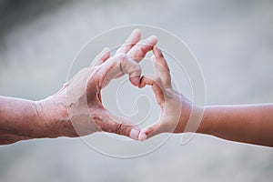 Grandmother and kid little girl making heart shape with hands