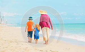 Grandmother with kids- little boy and girl- at beach