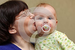 Grandmother kisses baby