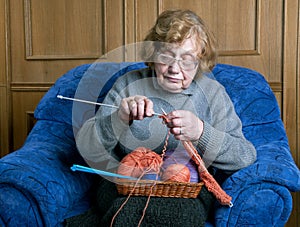 Grandmother knits with knittings in a room