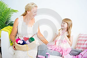 Grandmother knitting with granddaughter