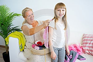 Grandmother knitting with granddaughter