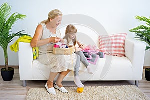 Grandmother knitting with granddaughter