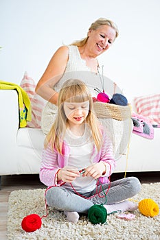 Grandmother knitting with granddaughter