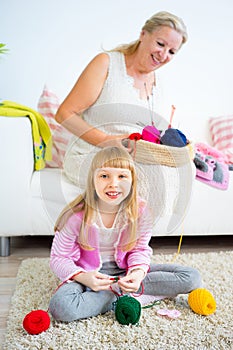 Grandmother knitting with granddaughter