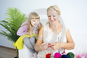 Grandmother knitting with granddaughter