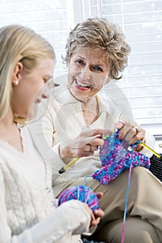 Grandmother knitting with granddaughter