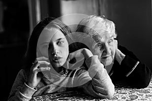 An grandmother listens as great-granddaughter talks on the phone.