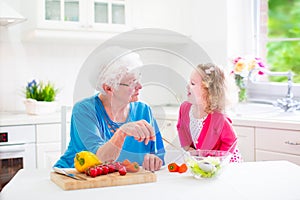 Grandmother and little girl making salad