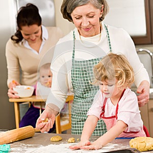 Grandmother with little girl prepare dough photo