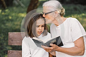 Grandmother and little girl reading holy bible. Study the holy bible together