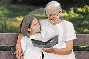 Grandmother and little girl reading holy bible. Study the holy bible together