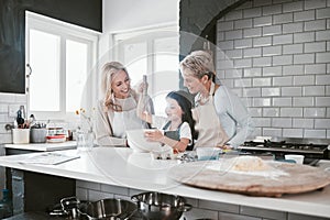 .Grandmother, mother and girl baking in kitchen having fun, bonding and spend quality time together. Family, love and