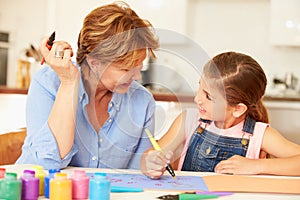 Grandmother Painting With Granddaughter At Home