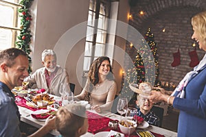 Grandmother placing food on the table for family Christmas dinner