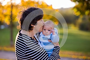 Grandmother playing in the park with her newborn baby grandchild