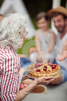 Grandmother prepared cake for a family picnic