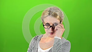 Grandmother puts on her glasses and speaks more quietly. Green screen