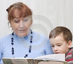 Grandmother reading a book grandson.