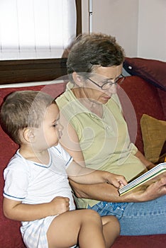 Grandmother reading book to baby