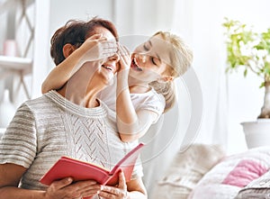 Grandmother reading a book to granddaughter