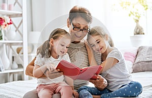 Grandmother reading a book to granddaughters