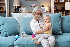 Grandmother retired woman doctor pediatric using stethoscope listening her grandson or granddaughter, young baby child lungs to