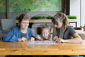 Grandmother`s daughter and granddaughter watching the menu in a cafe