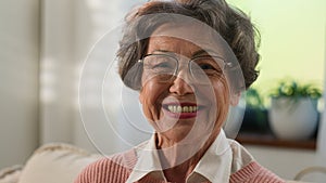 Grandmother senior woman old mature female elderly granny indoors at home smiling toothy looking camera happy middle