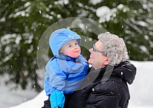 Grandmother Smiling at Grandson Outside in Winter