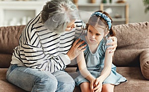 Grandmother supporting resentful granddaughter at home photo