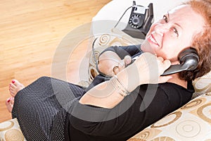 Grandmother talking on a retro rotary phone