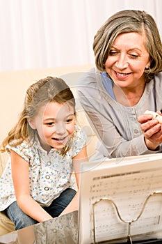 Grandmother teach young girl learn music notes