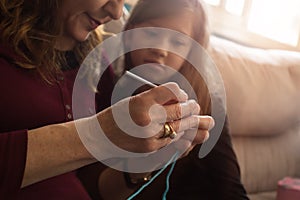 Grandmother teaching granddaughter to knit