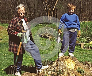 Grandmother teaching grandson lawn work photo