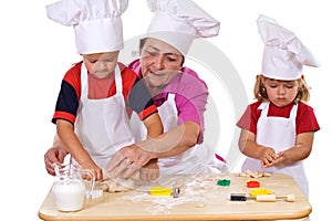 Grandmother teaching kids how to make cookies