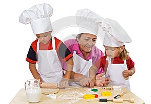 Grandmother teaching kids making cookies