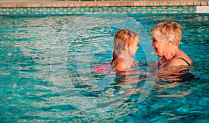 Grandmother teaching little granddaughter to swim