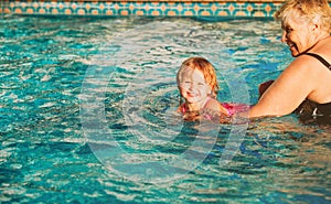 Grandmother teaching little granddaughter to swim