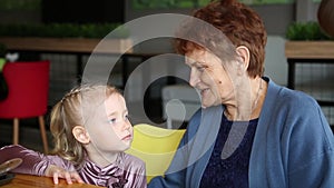 Grandmother tells a story to her granddaughter.