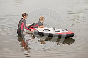 Grandmother train her grandson surfing in wetsuit