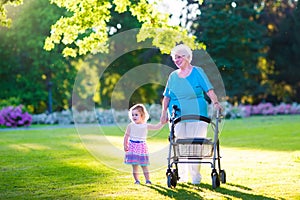 Grandmother with walker and little girl in a park