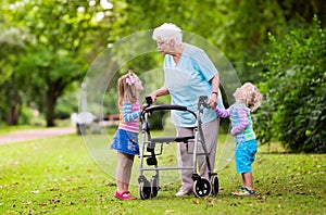 Grandmother with walker playing with two kids photo