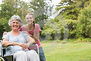 Grandmother in wheelchair and granddaughter smiling into the cam