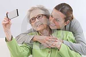 Grandmother and young grand-daughter photographing themselves