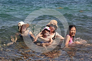 Grandmothers and nieces are swimming on the beach with happy faces