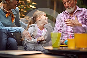 Grandpa amusing his granddaughter making funny face